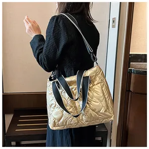 Woman wearing a stylish gold quilted down cotton tote bag with a trendy wide strap
