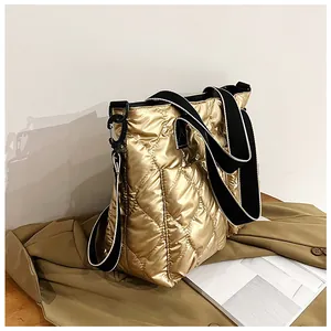Detailed view of large gold quilted space cotton tote bag with wide black straps.