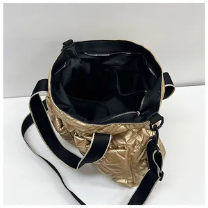 Detailed interior view of a gold quilted puffer tote bag showing storage pockets