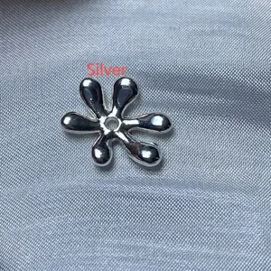 Gros plan d'un accessoire de bijoux DIY argenté en forme de fleur avec trou central