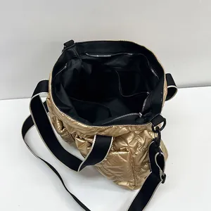 Elegant gold quilted puffer tote bag with spacious black interior and wide shoulder strap