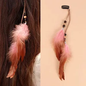 Dettaglio della clip per capelli in piume bohémien con nappe rosa e marroni e perline in legno.