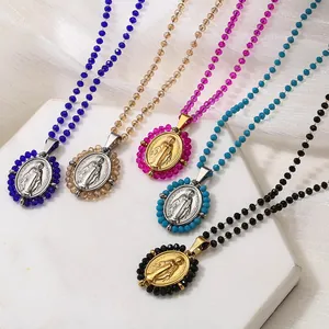 Detail view of colorful beaded necklaces with oval stainless steel Virgin Mary pendants.