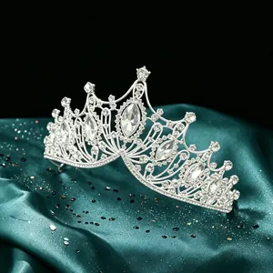 Close-up of luxury Baroque bridal crown with marquise-cut crystals on green satin