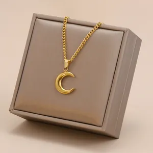 Detailed view of polished 18K gold-plated crescent moon pendant resting on a premium jewelry box