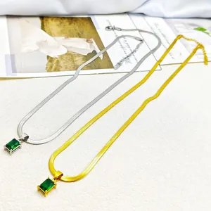 Detailed view of luxury gold and silver snake chains with emerald green square pendants
