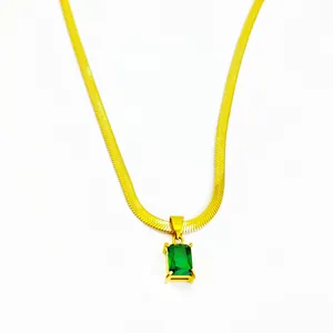 Close-up of emerald green zircon pendant on gold-plated stainless steel blade chain