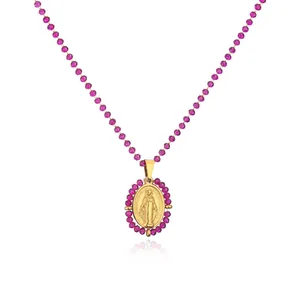 Close-up view of a golden stainless steel oval Mary medallion with purple beads detail