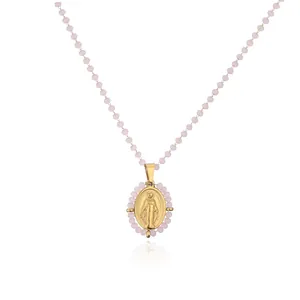 Detail of elegant gold-plated Virgin Mary oval pendant necklace with pink crystal beads