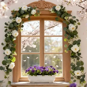Detailansicht der künstlichen Kamelien- und Eukalyptusrebe an einem Fensterrahmen.