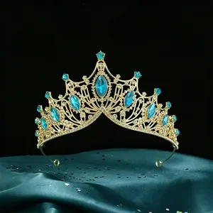 A detailed view of a luxurious golden Baroque bridal tiara with blue marquise gemstones.