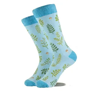 Détail de chaussettes bleu clair avec des motifs botaniques de feuilles et champignons.