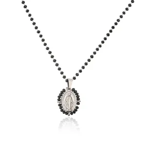 Close-up of a stainless steel Virgin Mary pendant necklace with black beaded chain.