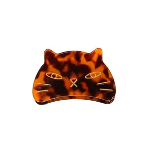 Close-up of a vintage tortoiseshell acetate cat hair claw clip with golden wire details.