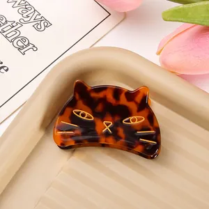 Close-up of a tortoiseshell cat-shaped acetate hair claw clip with gold accents