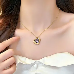 Elegant gold necklace featuring a heart-shaped purple crystal pendant detail view