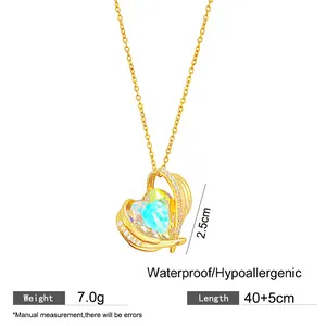 Close-up detail of gold heart pendant with iridescent blue stone and measurements