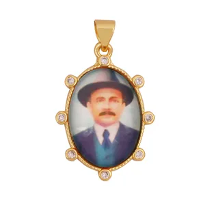 Detail of vintage 18K gold plated pendant with religious figure portrait and zircons