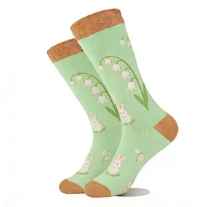 Détail de chaussettes en jacquard vert clair avec motifs de muguet et de lapin