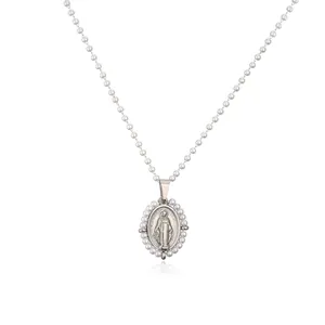 Detailed macro view of silver Virgin Mary pendant with pearl beads on a necklace
