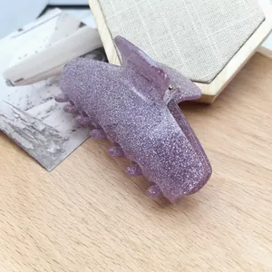 Detailed view of the sparkling purple cat-ear shaped hair claw clip texture