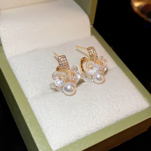 Élégantes boucles d'oreilles fleurs et perles françaises dans un écrin de luxe vert