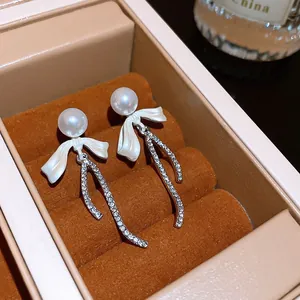 Elegant French style white pearl bow earrings featuring exquisite sparkling rhinestone tails