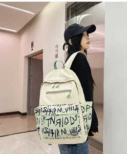 Asian woman wearing a trendy cream and green graffiti backpack in modern setting
