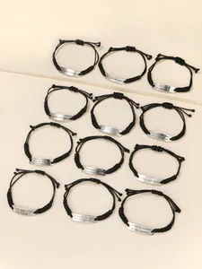Détails de bracelets tressés en cordon de cire noire avec plaques en alliage de texte motivant