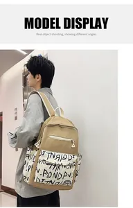 Trendy khaki backpack with black graffiti pattern shown on an Asian male model.