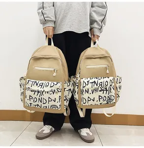 Two stylish beige student backpacks showing size comparison and graffiti detail