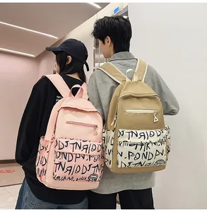 Back view of models wearing pink and khaki graffiti print large capacity backpacks