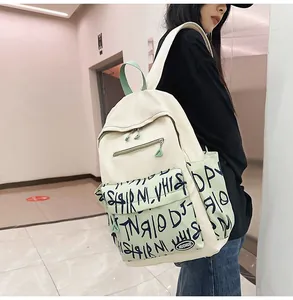 Asian model wearing a cream and mint green graffiti backpack for school and casual outings