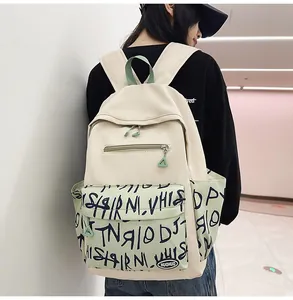 Detail view of stylish cream backpack featuring a trendy green graffiti pocket design