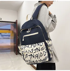 Side view of a trendy navy blue and cream graffiti print student backpack on a model