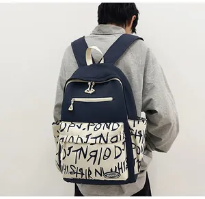 Detailed back view of a navy blue student backpack with graffiti pocket on casual model