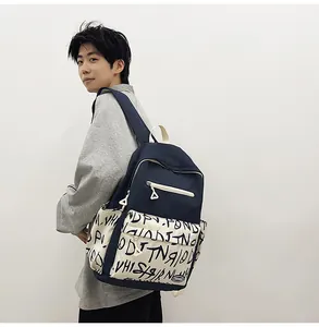 Stylish navy blue and white graffiti backpack worn by male model in studio view