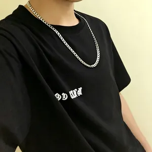 Detailansicht einer silbernen Edelstahl-Hiphop-Panzerkette auf einem schwarzen T-Shirt