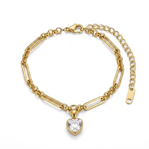 Detailweergave van gouden hartvormige hanger en paperclip kettingarmband van staal