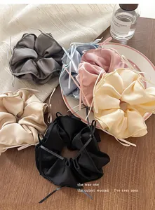 Close-up of elegant ballet-style satin hair scrunchies with ribbons in various colors.