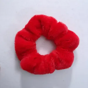 Gros plan sur la texture en peluche rouge douce de ce chouchou automnal duveteux.