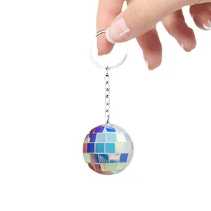 Porte-clés boule disco irisée tenu à la main sur un fond blanc propre.