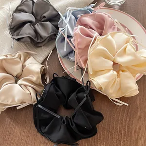 Elegant ballet style satin scrunchies with delicate ribbon bows in assorted pastel colors.