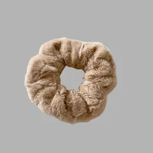 Vue détaillée montrant la texture douce en fausse fourrure d'un chouchou en peluche brun.