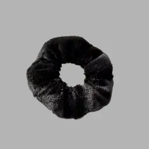 Vue détaillée d'un chouchou en peluche noire douce avec une texture en fausse fourrure