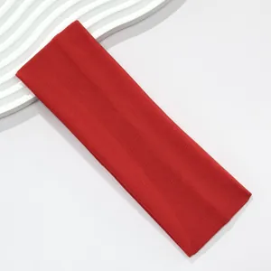 Macro view of wide red elastic headband with fine knit fabric texture detail.