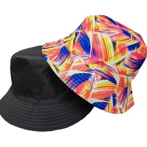 Primo piano di cappelli bucket reversibili con stampa astratta e opzione nero tinta unita