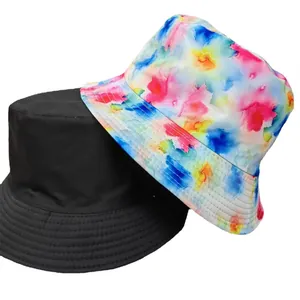 Primo piano di cappelli bucket reversibili in nero tinta unita e stampe tie-dye