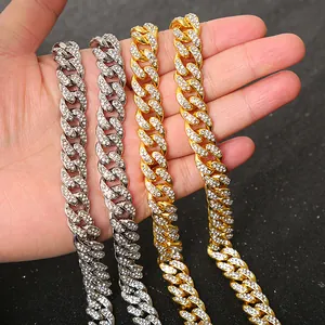 Close-up of gold and silver iced out Cuban link chains with full rhinestones.