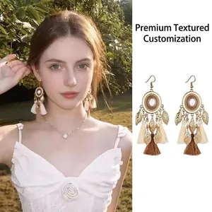 Bohemian ethnic style long tassel earrings with golden leaf charms shown on a model